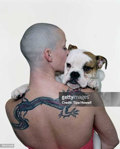 woman with tattoo holding bulldog, rear view - white dragon tattoo stock pictures, royalty-free photos & images