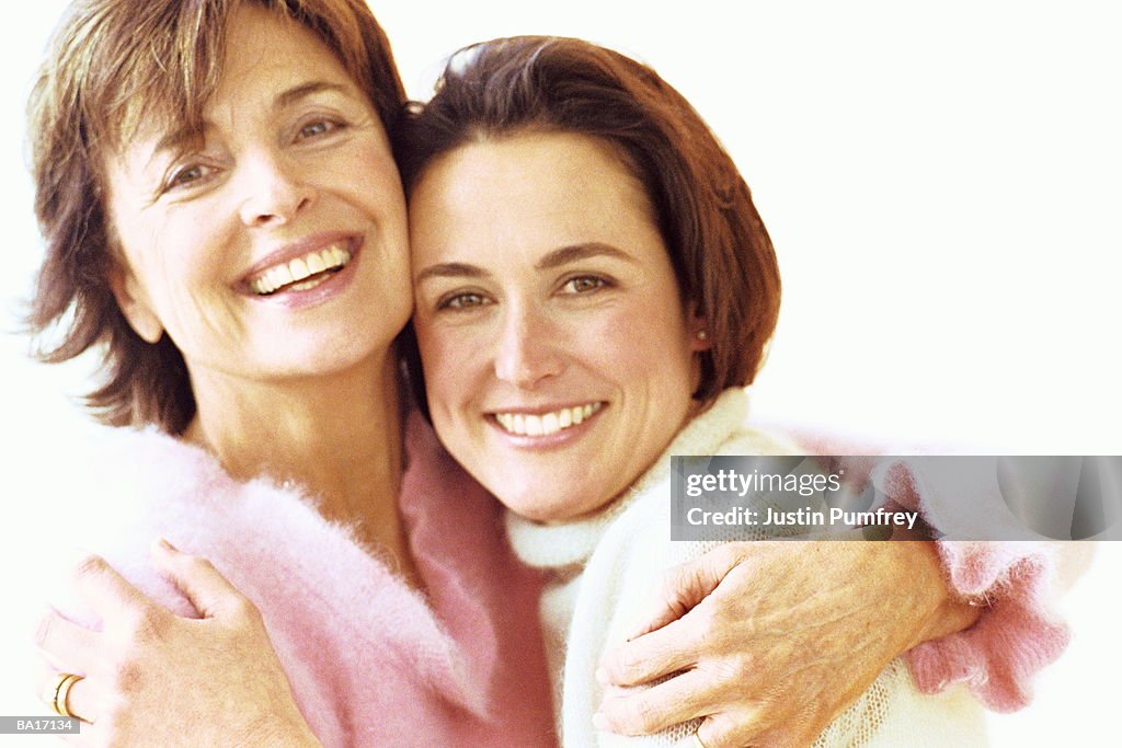 Mother and adult daughter embracing, portrait, close-up