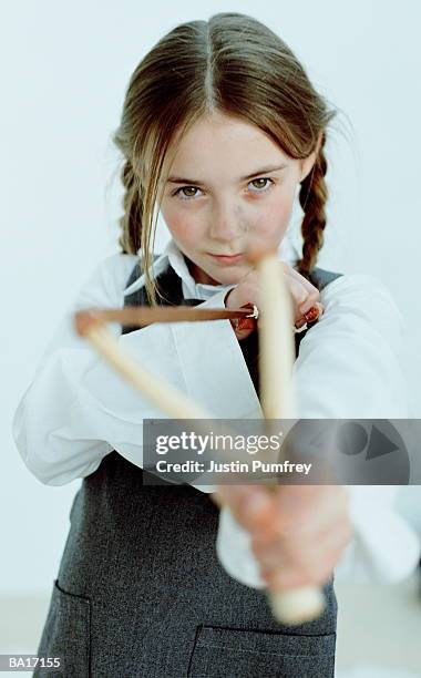 schoolgirl (8-10) stretching elastic of catapult, close-up, portrait - zwiesel stock-fotos und bilder