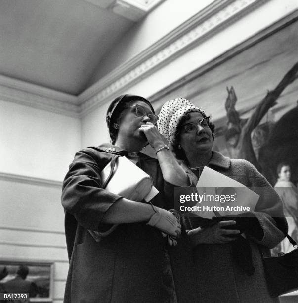 Two mature women in art gallery