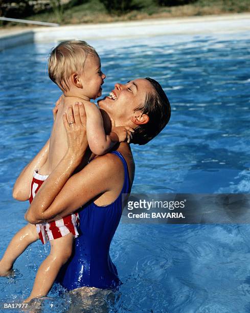 mother and son (4-6) years old in pool, smiling - 25 29 years stock-fotos und bilder