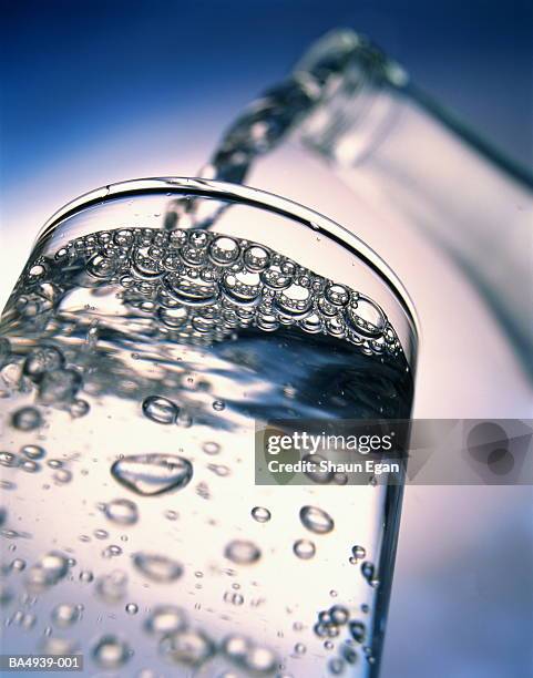 clear liquid being poured from bottle into glass, low angle view - purified water 個照片及圖片檔