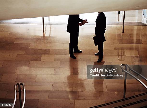 businessmen talking in foyer, low-section - justin stock pictures, royalty-free photos & images