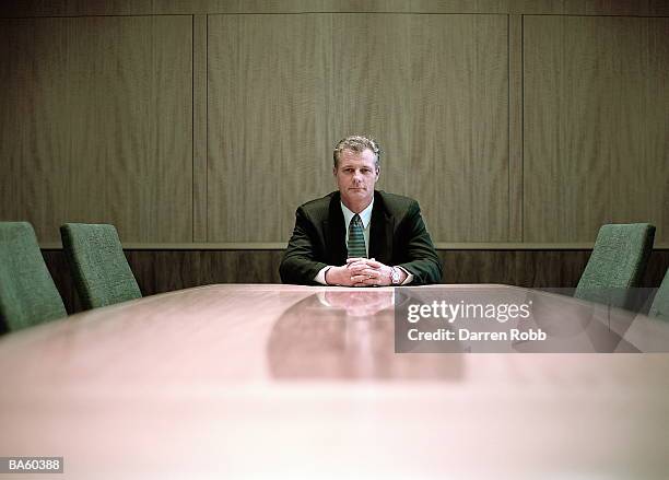 businessman at conference table, portrait - businessman sitting in chair stock-fotos und bilder