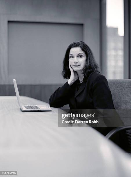 businesswoman at conference table with laptop, portrait - black and white portrait woman stock pictures, royalty-free photos & images
