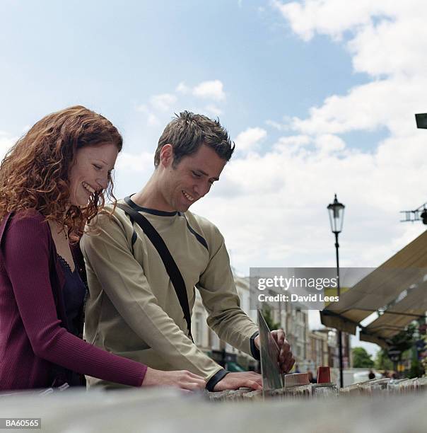 young couple looking at records at market stall, smiling - audio software stock pictures, royalty-free photos & images