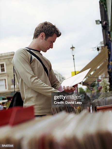 young man looking at records at market stall - audio software stock pictures, royalty-free photos & images