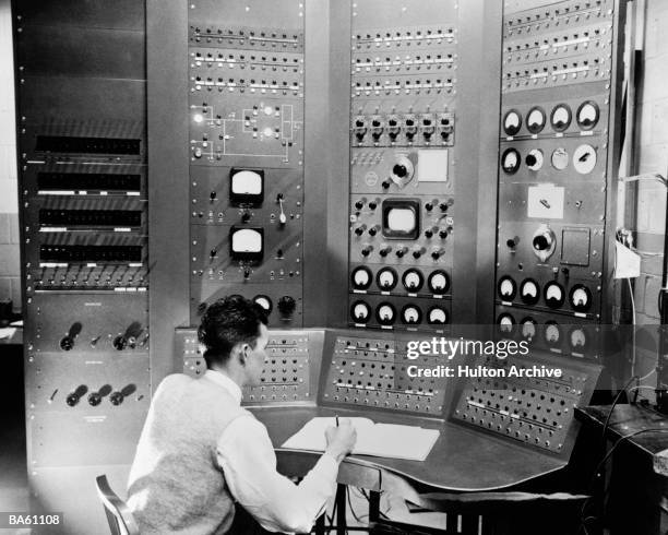 Physicist Ralph McCreary seated at the remote control panel for the University of Rochester's 25 000 volt cyclotron, 12th January 1949