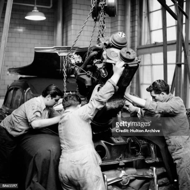 Students at the Brooklyn School of Automotive Trades carefully replace a car's engine after a carbon and valve job, 1956