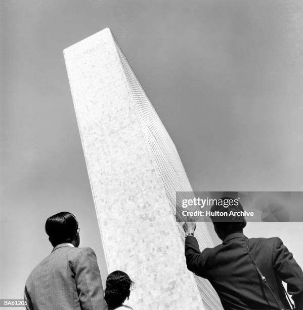 Three International Exchagne students from Japan and India look at the United Nations building in New York City. Circa 1952