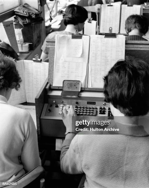 Women operating 'Betsy' a machine which calculates winning bets automatically, at the largest betting shop in the country, William Hill's at St...