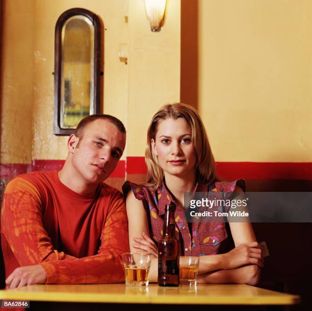 young couple at table in cafe, portrait - half shaved hair stockfoto's en -beelden