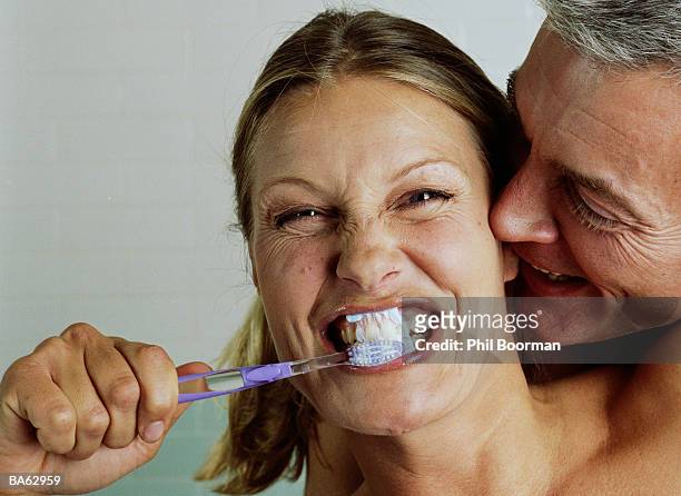 couple embracing, woman brushing teeth, portrait, close-up - phil stock pictures, royalty-free photos & images