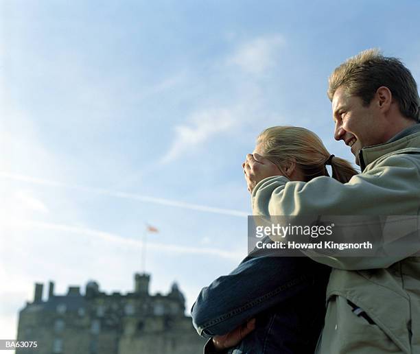 scotland, edinburgh castle, man with hands placed over woman's face - edinburgh castle people stock pictures, royalty-free photos & images