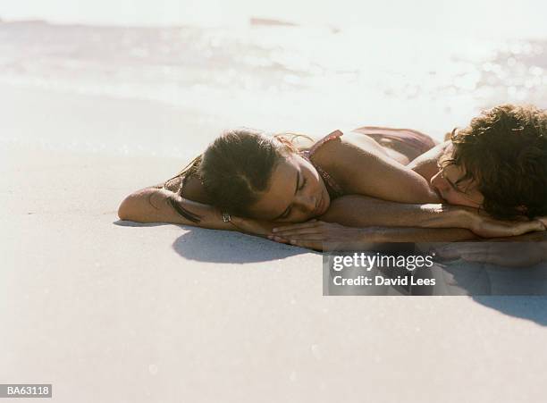 young couple lying asleep on beach - young couple beach bildbanksfoton och bilder