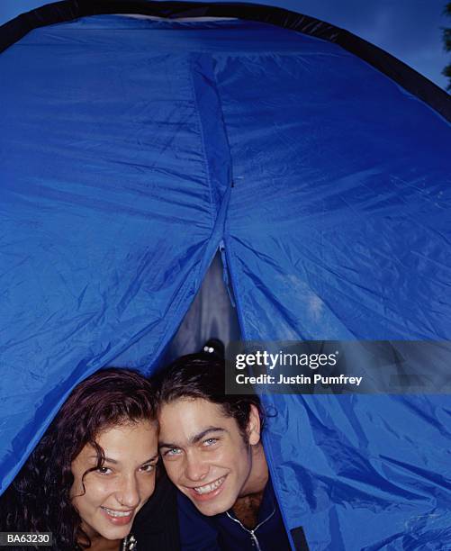 young couple looking through tent opening, smiling, portrait - opening night of dirty dancing the classic story on stage arrivals stockfoto's en -beelden