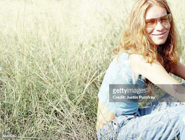 young woman on grass wearing sunglasses, close-up, portrait - justin stock pictures, royalty-free photos & images