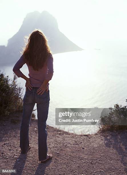 spain, ibiza, es vedra, woman looking out to sea, rear view - justin stock pictures, royalty-free photos & images