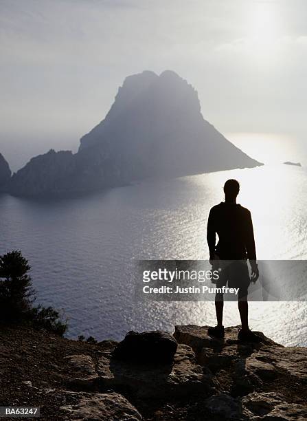 spain, ibiza, es vedra, man looking out to sea, silhouette - justin stock pictures, royalty-free photos & images