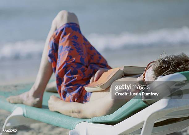 young man relaxing on sun lounger, close-up - justin stock pictures, royalty-free photos & images