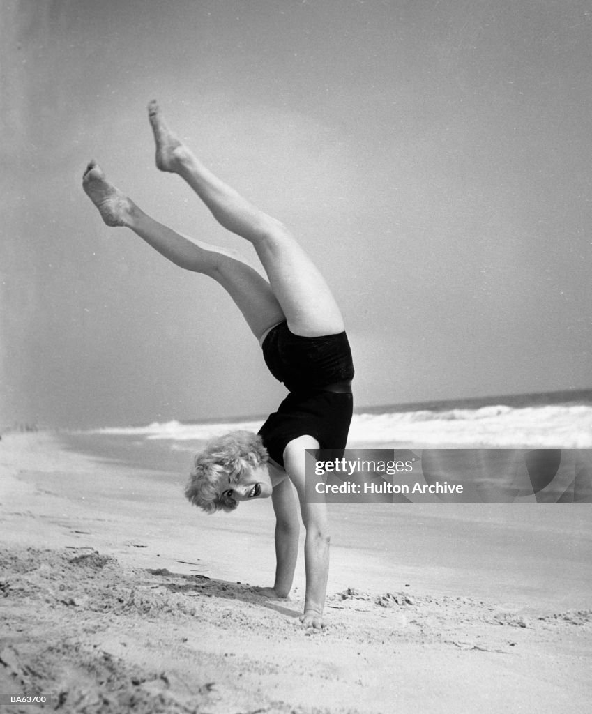 Woman does handstand on the beach (B&W)