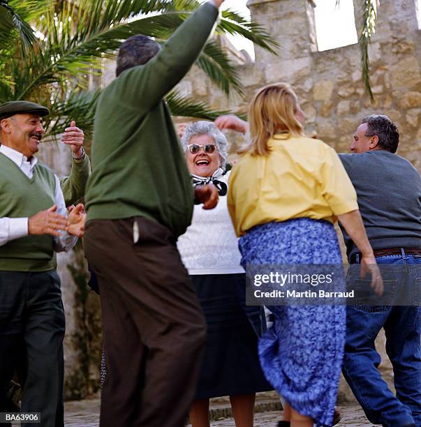 group of mature people dancing together outdoors - mujeres de mediana edad fotografías e imágenes de stock