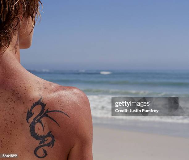 young man with serpent tattoo, on beach, rear view, close-up - justin stock pictures, royalty-free photos & images