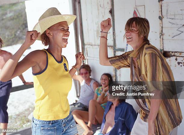 young man and woman dancing on veranda of beach hut - justin stock pictures, royalty-free photos & images