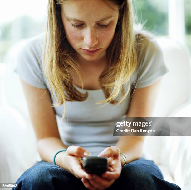 teenage girl (13-15) using mobile phone, close-up - dan kenyon bildbanksfoton och bilder