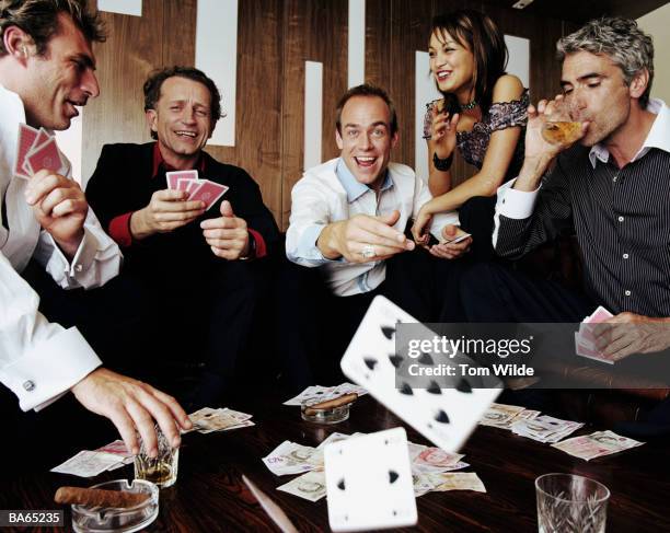 four mature men playing cards watched by young woman - tom chance stock pictures, royalty-free photos & images