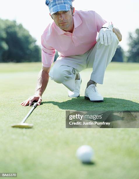 male golfer lining up a putt - justin stock pictures, royalty-free photos & images