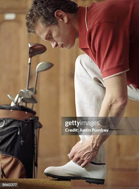 man tying golf shoe lace, close-up - bolsa de golf fotografías e imágenes de stock