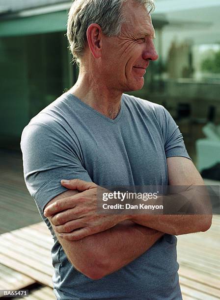 mature man standing outdoors with arms folded, close-up - dan kenyon bildbanksfoton och bilder