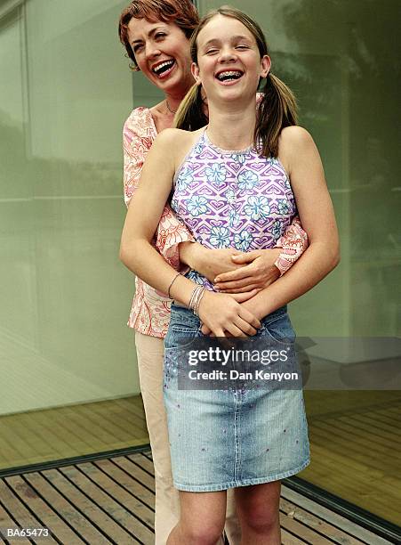 mother with arms around daughter (12-14), laughing, outdoors - dan kenyon bildbanksfoton och bilder