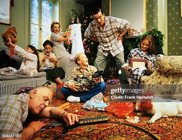christmas day in living room,family and dog unwrapping & enjoying gift - pet christmas gifts stock pictures, royalty-free photos & images