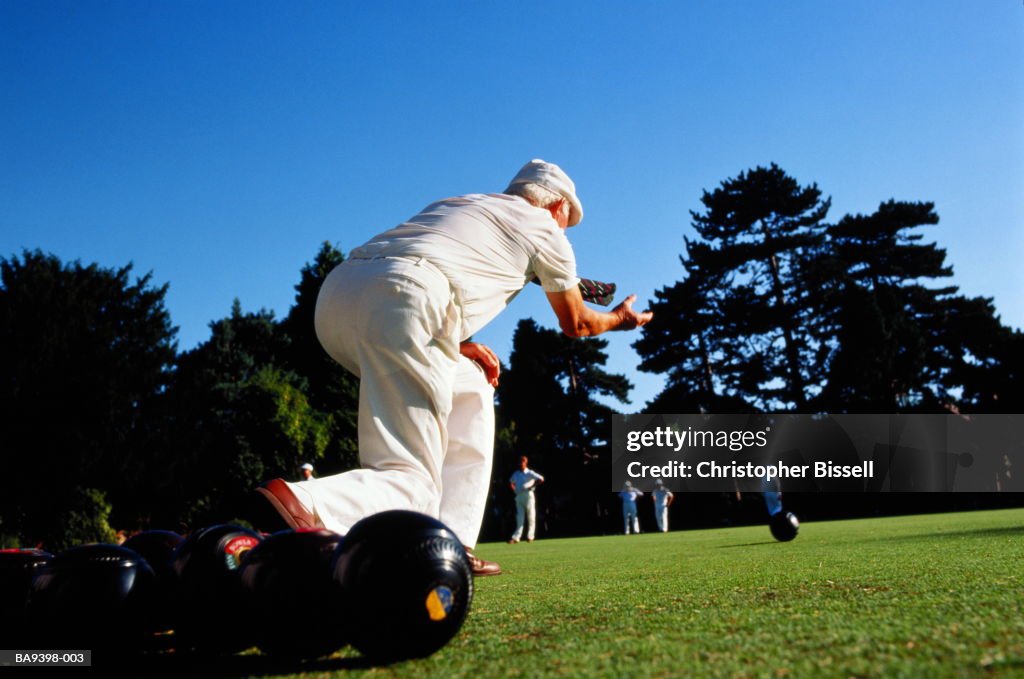 Elderly man lawn bowling, low  angle, rear view