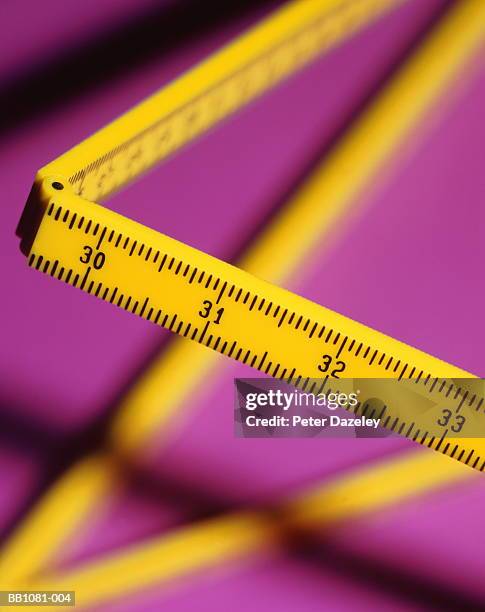 folding rule, inch scale prominent, purple background, close-up - duimstok stockfoto's en -beelden