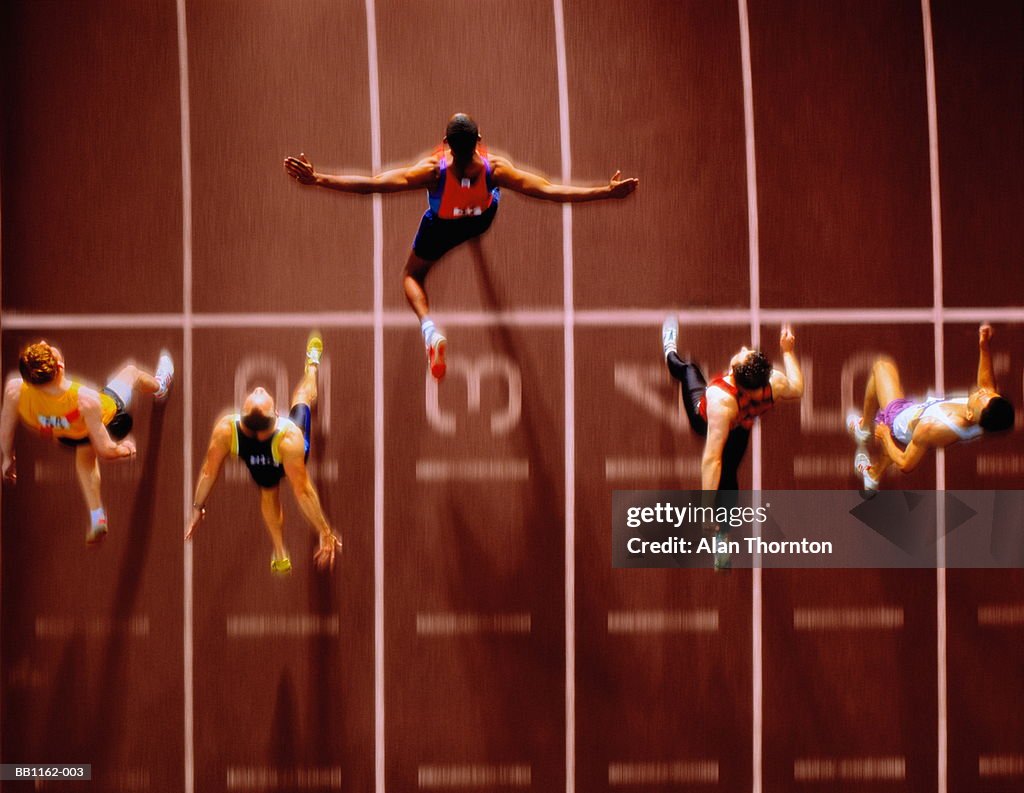 Athletes in race crossing finishing line, overhead view (Composite)