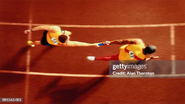 athletes passing baton in relay race, overhead, (digital composite) - stafett bildbanksfoton och bilder