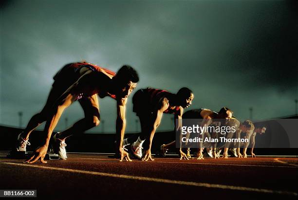 athletes on starting-blocks, low angle view (digital composite) - häcklöpning löpgren bildbanksfoton och bilder