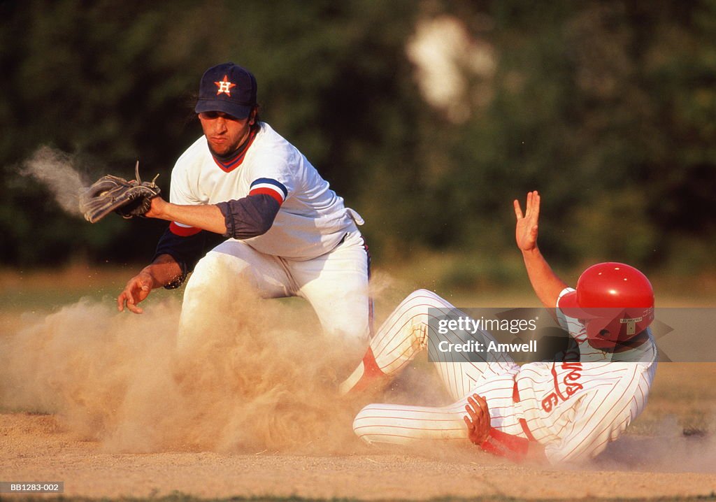 Baseball,player diving for base in cloud of dust
