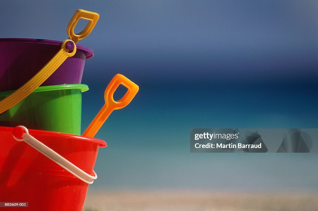 Colourful child's plastic buckets and spades on beach