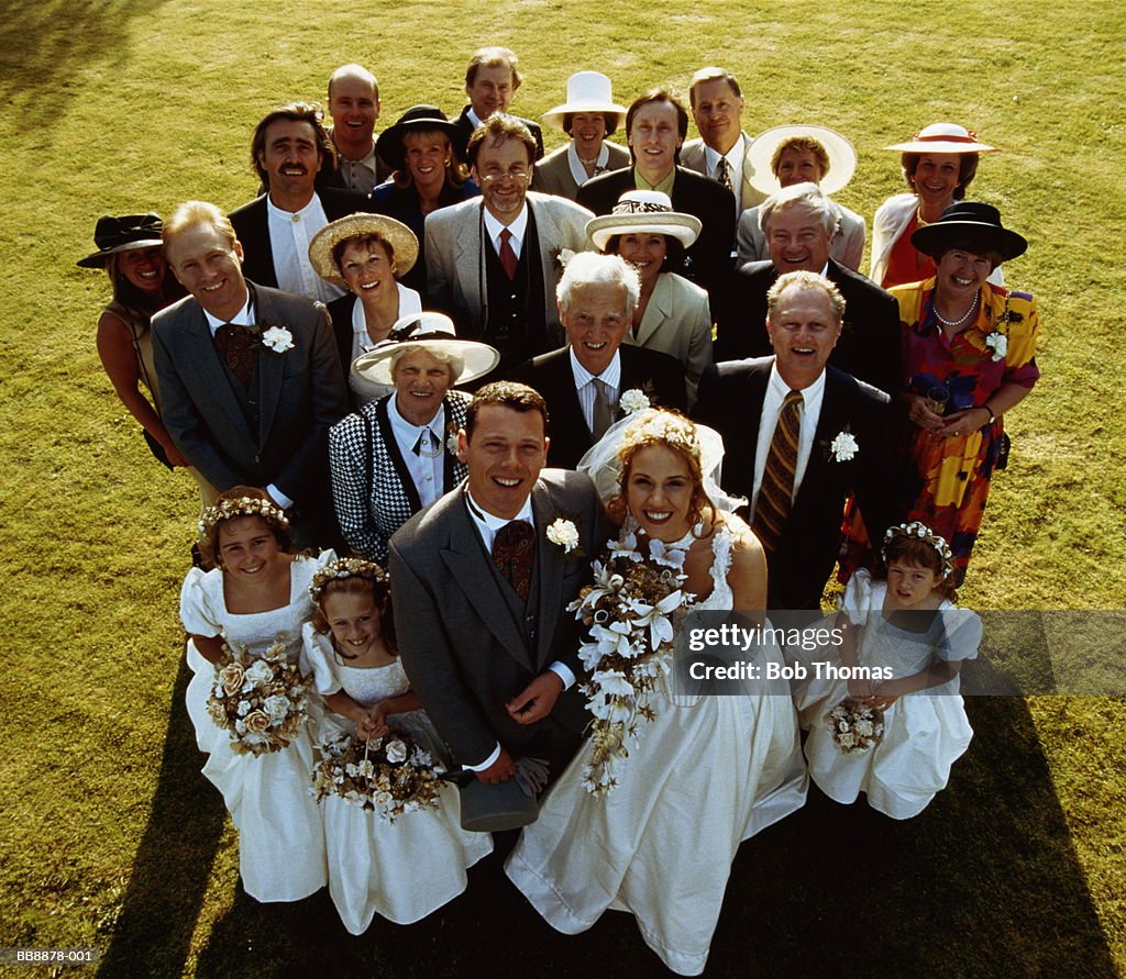 Portrait of bride, groom and family standing on lawn, elevated view