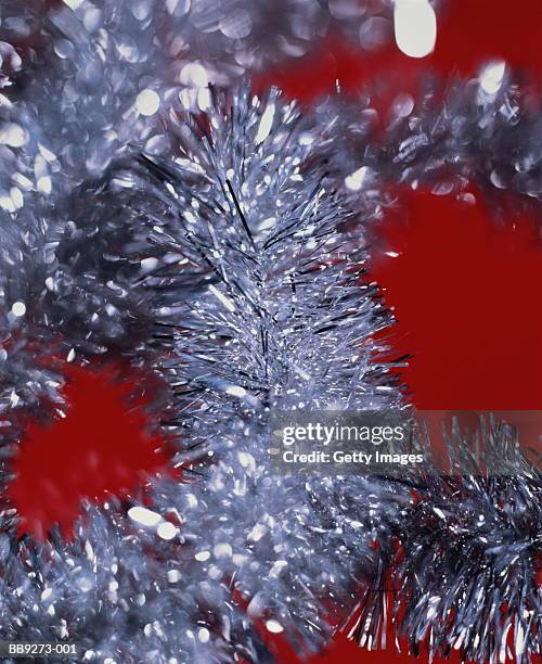 silver tinsel, red background, close-up - lametta stock-fotos und bilder
