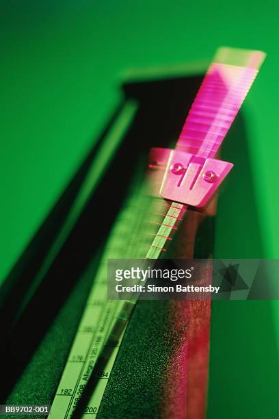 metronome with ticking pendulum (blurred motion, brightly lit) - metronome stock pictures, royalty-free photos & images