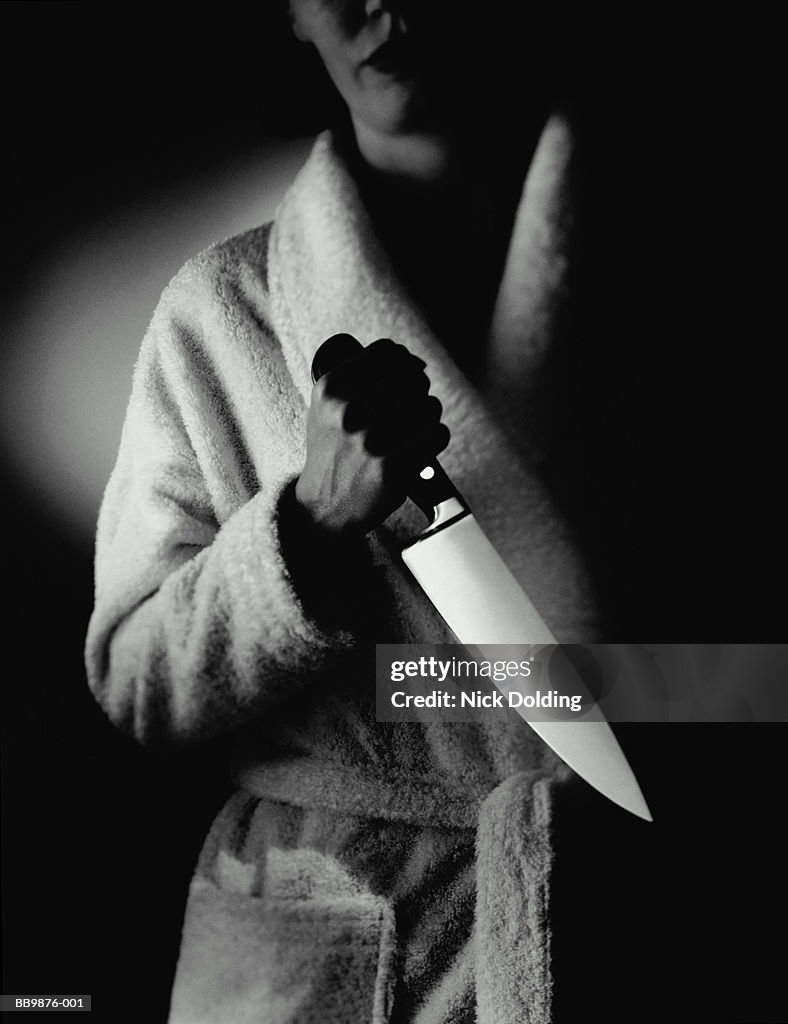 Woman in bathrobe, clutching large kitchen knife (B&W)