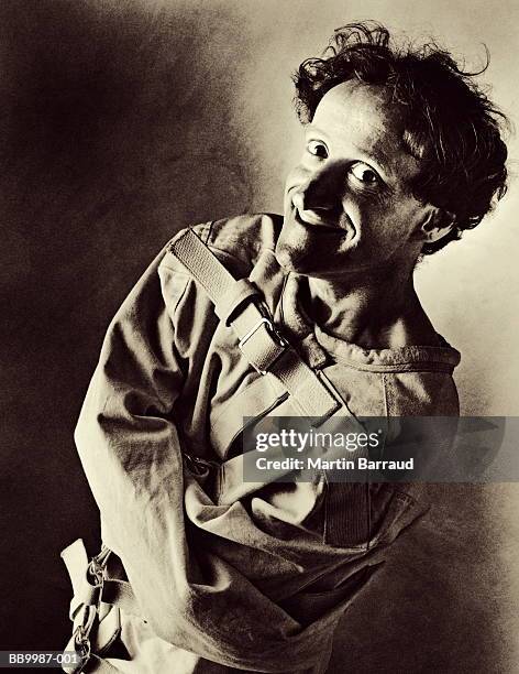 man wearing strait-jacket, smiling, portrait (toned b&w) - straight jacket stock pictures, royalty-free photos & images