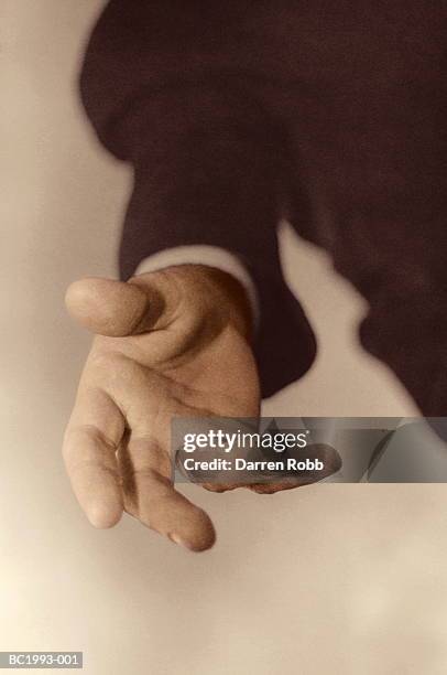 businessman's outstretched hand, close-up (tinted b&w) - 招き寄せる ストックフォトと画像