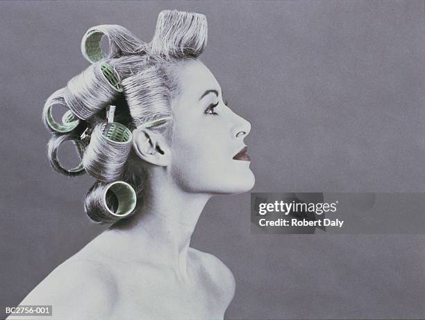 naked young woman wearing curlers in her hair, profile (tinted b&w) - hair curlers stockfoto's en -beelden