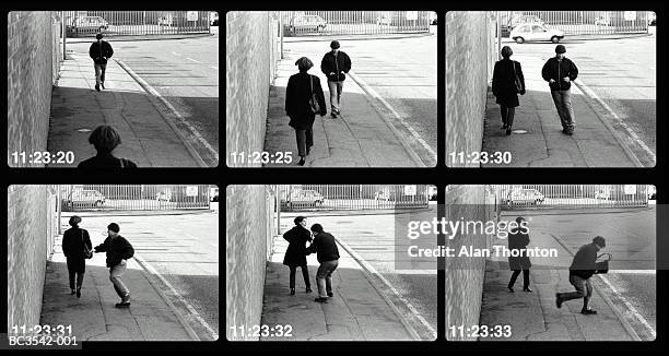 man mugging woman in street (video still, digital composite) - cctv stockfoto's en -beelden